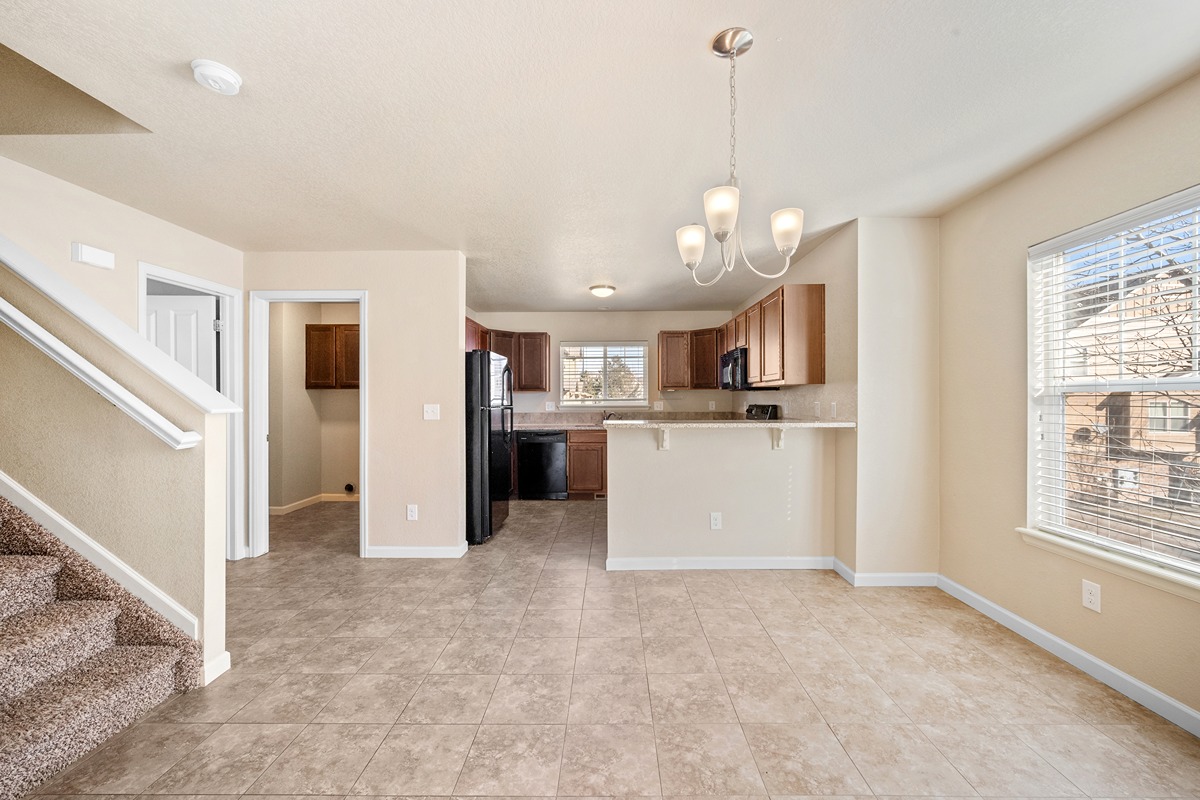 A spacious living room with a staircase leading to the upper floor.